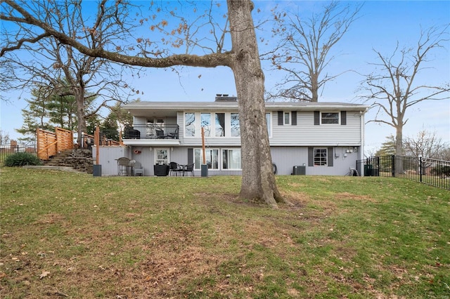 rear view of property with central AC unit, a balcony, a yard, and a patio