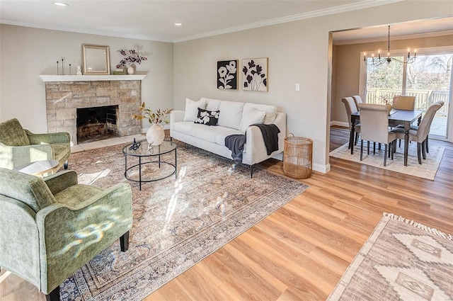 living room featuring wood-type flooring, a stone fireplace, ornamental molding, and a notable chandelier