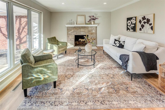 living room featuring wood-type flooring, a fireplace, and ornamental molding