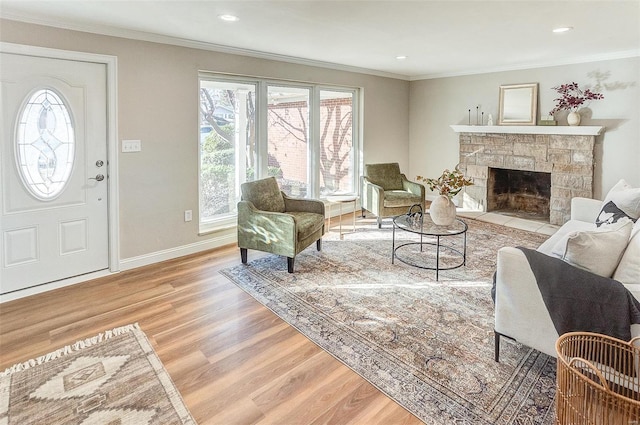 living room featuring a stone fireplace, crown molding, and light hardwood / wood-style flooring