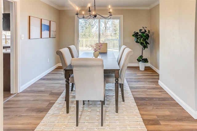 dining space with crown molding, an inviting chandelier, and hardwood / wood-style flooring