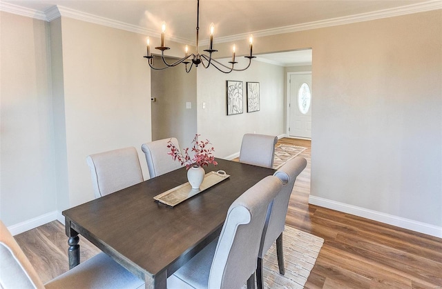 dining space with ornamental molding, a notable chandelier, and hardwood / wood-style flooring