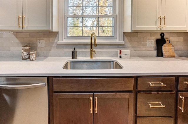 kitchen with white cabinets, dishwasher, decorative backsplash, and sink