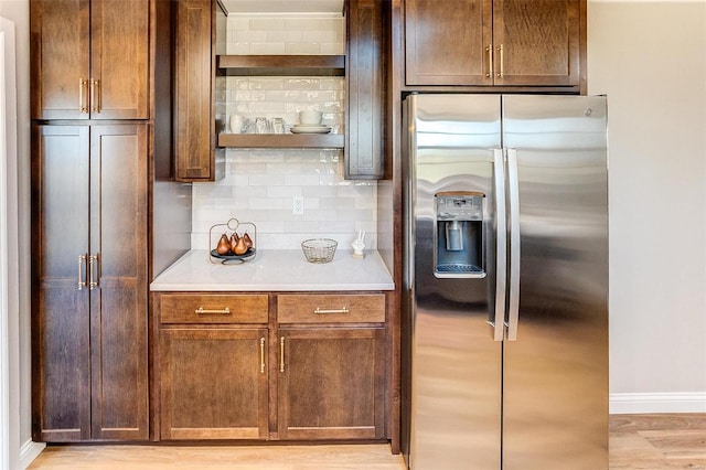 kitchen featuring decorative backsplash, stainless steel fridge, and light hardwood / wood-style floors