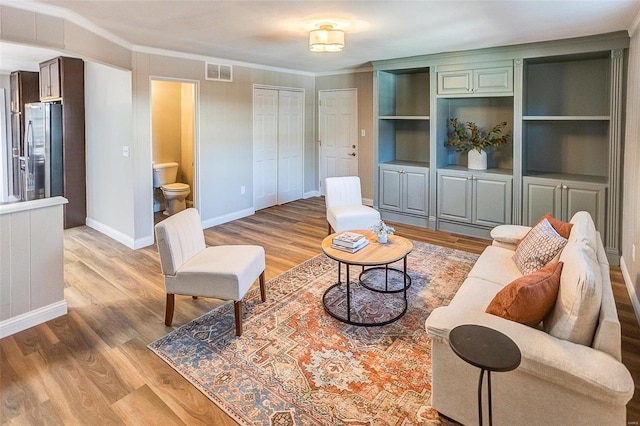 living room featuring hardwood / wood-style flooring and ornamental molding