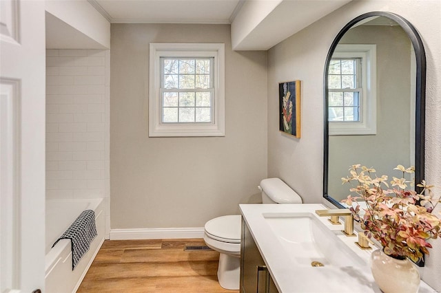 bathroom with a wealth of natural light, toilet, ornamental molding, and hardwood / wood-style flooring