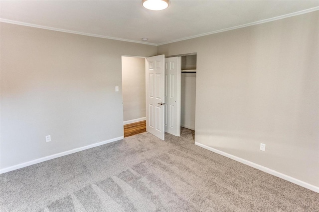 unfurnished bedroom featuring carpet, ornamental molding, and a closet