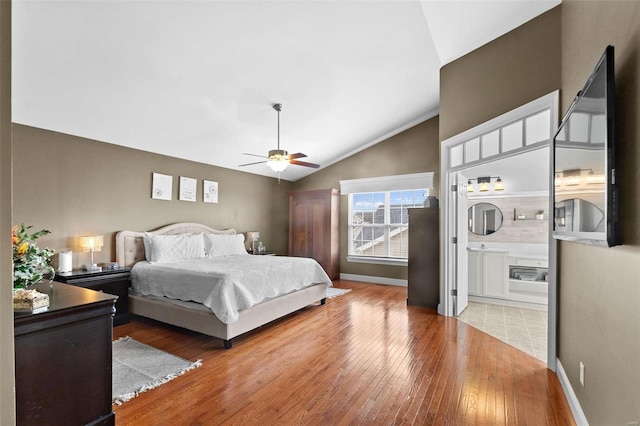 bedroom with hardwood / wood-style flooring, ceiling fan, lofted ceiling, and ensuite bathroom