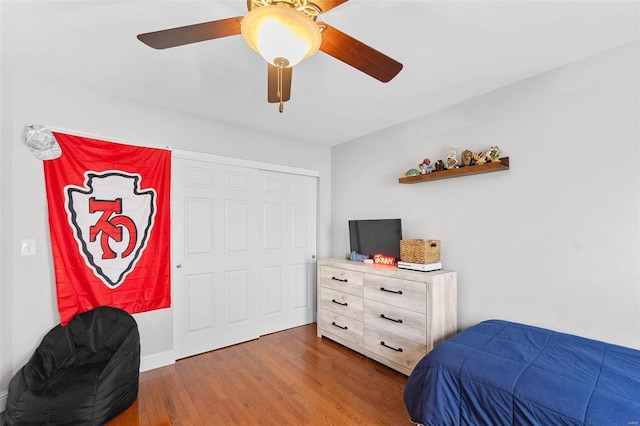 bedroom with hardwood / wood-style floors, ceiling fan, and a closet