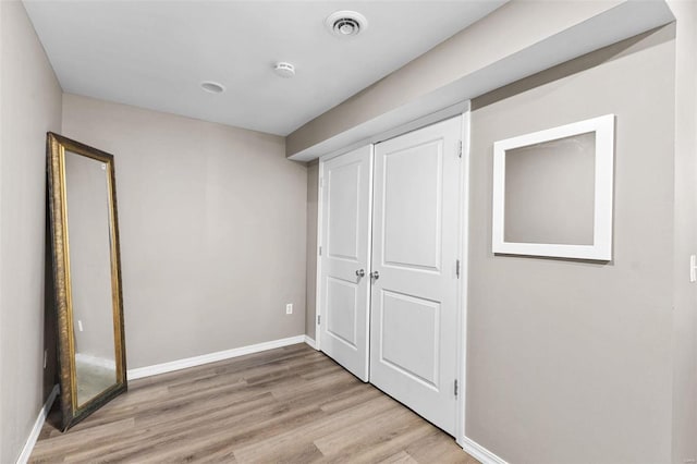 unfurnished bedroom with a closet and light hardwood / wood-style flooring