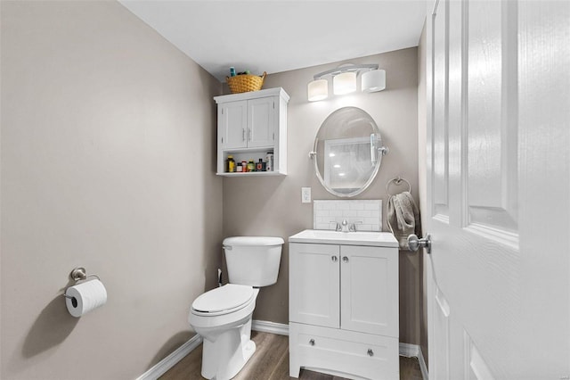 bathroom with hardwood / wood-style floors, vanity, toilet, and backsplash