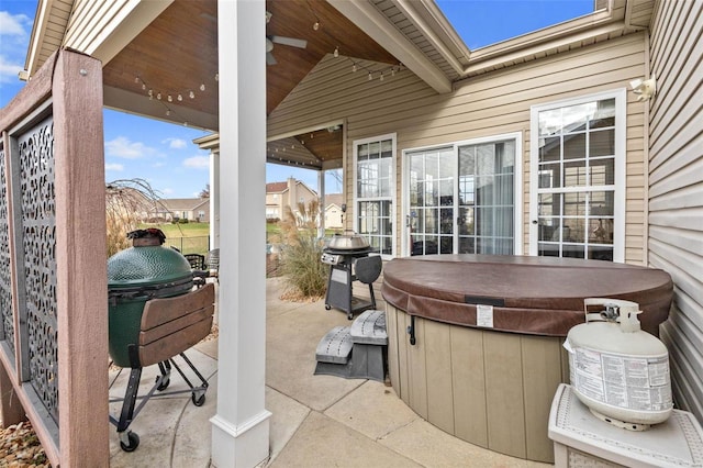 view of patio featuring a grill, ceiling fan, and a hot tub