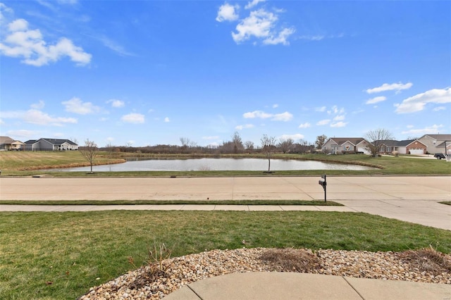 view of community featuring a lawn and a water view