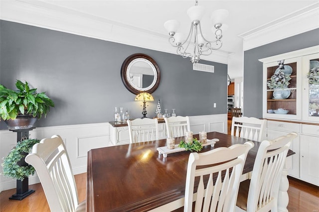 dining room featuring a chandelier, light hardwood / wood-style flooring, and ornamental molding