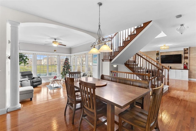 dining area featuring light hardwood / wood-style flooring, ornate columns, ceiling fan, and crown molding