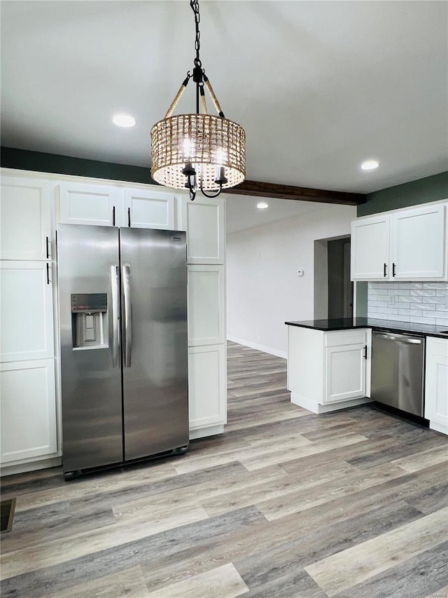 kitchen featuring backsplash, white cabinets, light wood-type flooring, decorative light fixtures, and stainless steel appliances