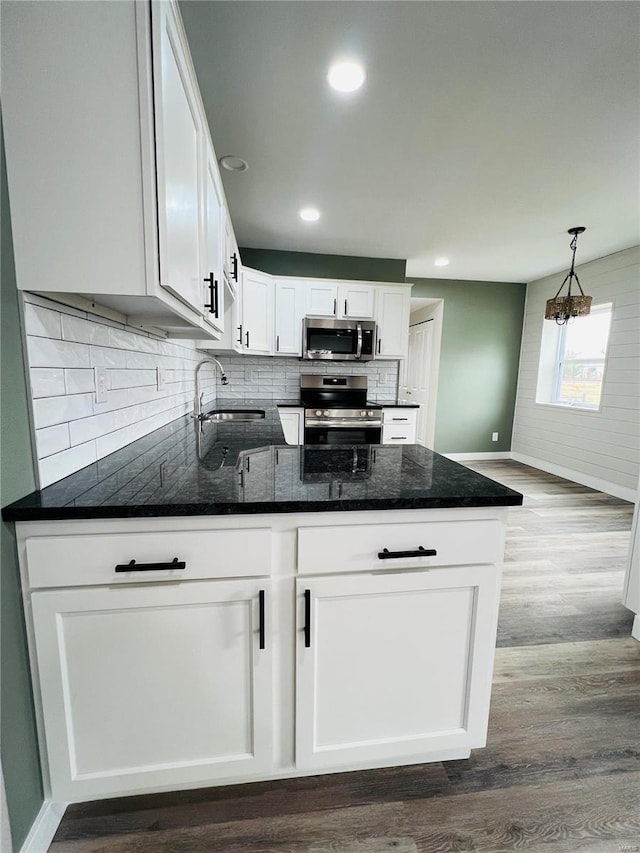 kitchen featuring sink, dark hardwood / wood-style floors, pendant lighting, white cabinets, and appliances with stainless steel finishes