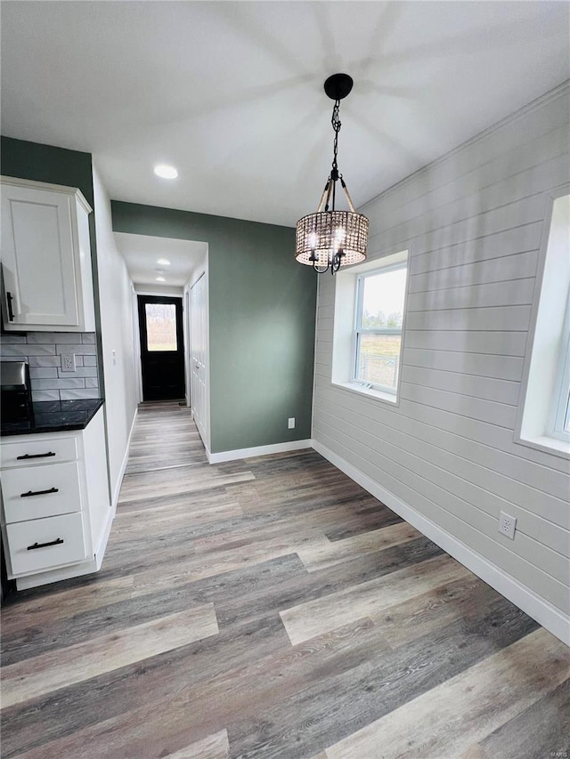 unfurnished dining area featuring a chandelier and light wood-type flooring