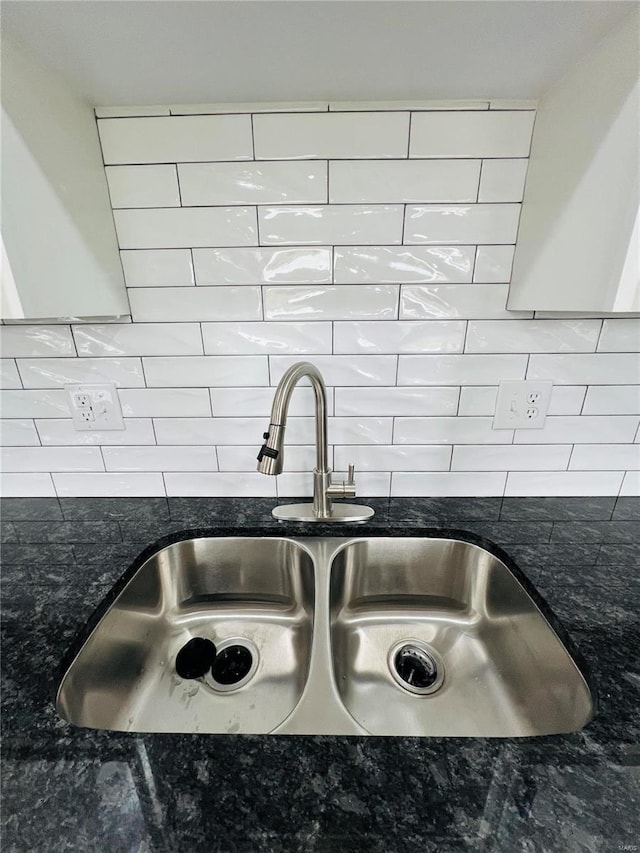 interior details featuring dark stone countertops, decorative backsplash, and sink