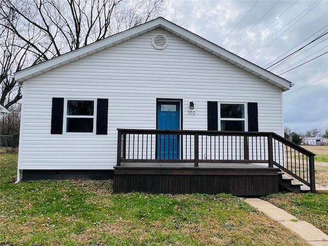 back of property with a lawn and a wooden deck