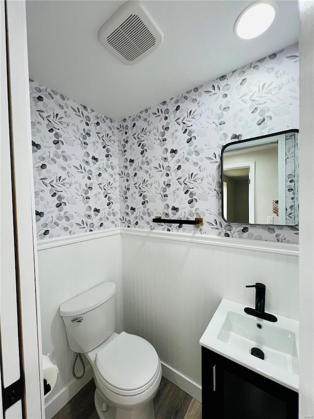 bathroom with hardwood / wood-style floors, vanity, and toilet