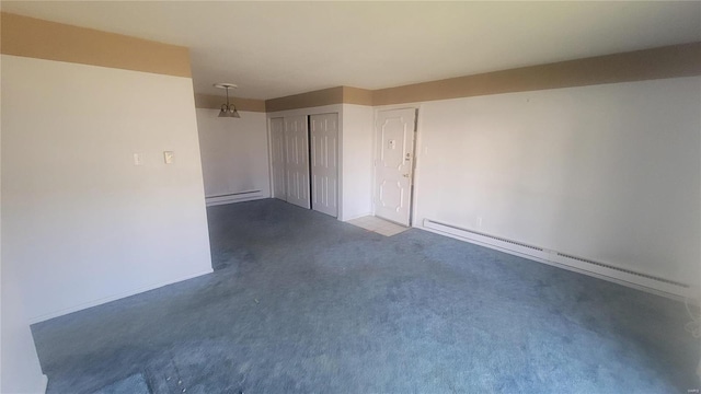 empty room featuring dark colored carpet and a baseboard heating unit