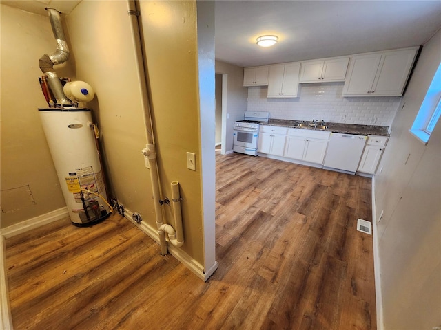 kitchen featuring white cabinets, white appliances, backsplash, and water heater