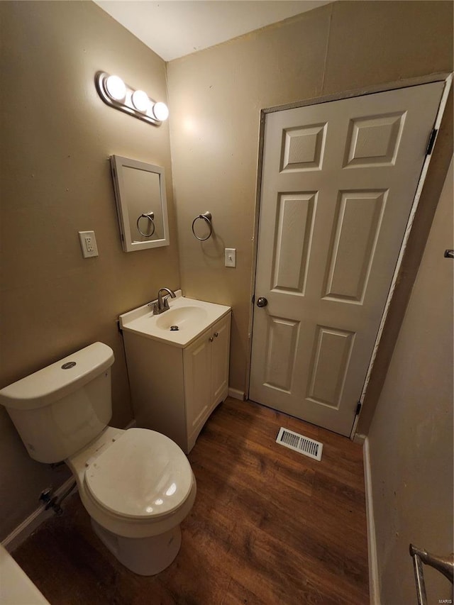 bathroom with hardwood / wood-style floors, vanity, and toilet