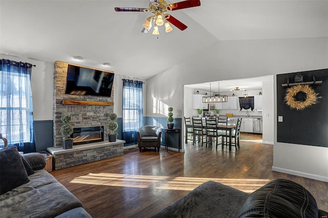 living room with sink, a fireplace, vaulted ceiling, ceiling fan, and dark hardwood / wood-style floors