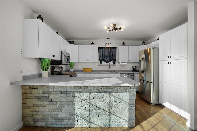 kitchen with sink, white cabinetry, kitchen peninsula, and appliances with stainless steel finishes