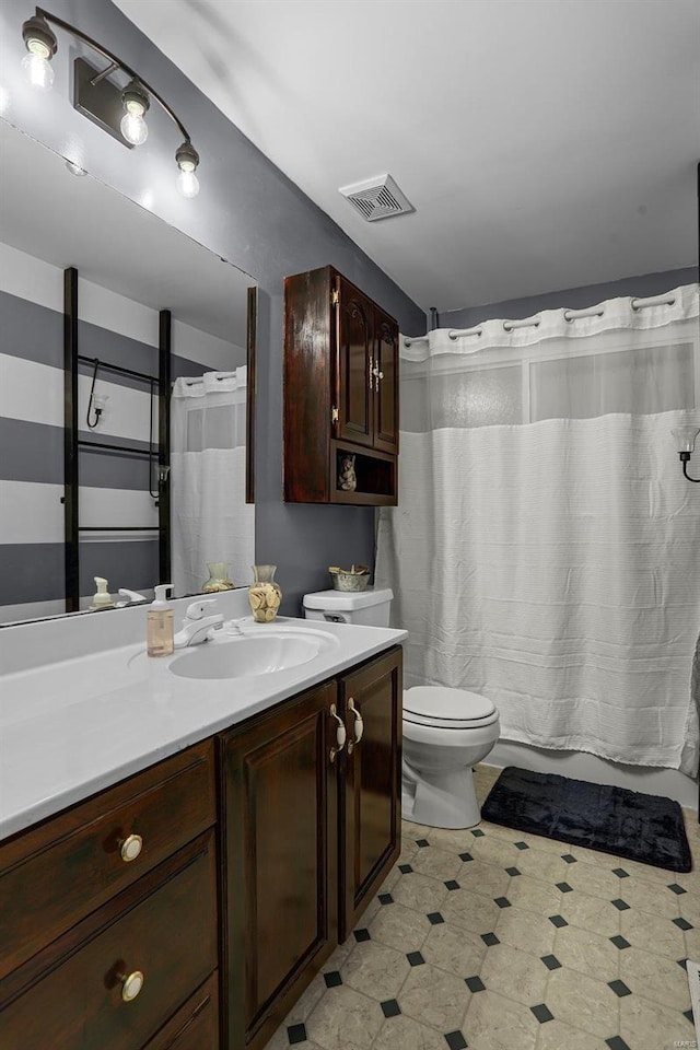 bathroom with toilet, vanity, and curtained shower