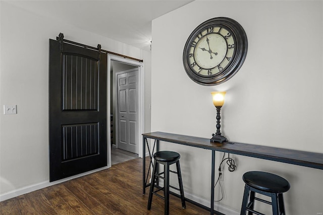 foyer entrance featuring a barn door and dark hardwood / wood-style floors