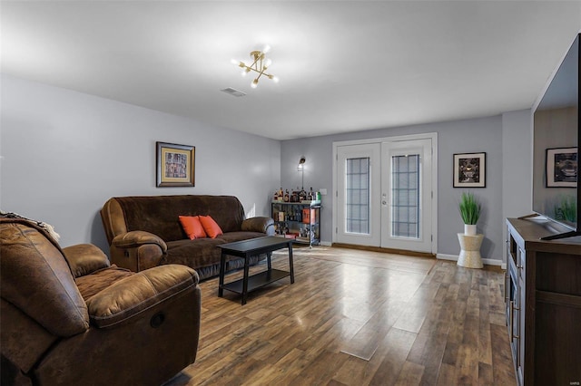 living room featuring french doors, hardwood / wood-style floors, and a chandelier