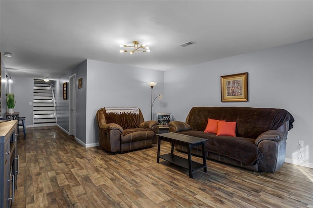 living room featuring an inviting chandelier and dark hardwood / wood-style flooring