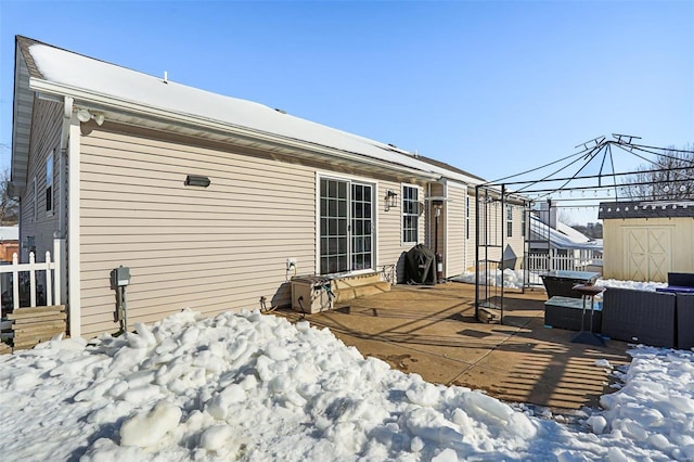 snow covered house with outdoor lounge area