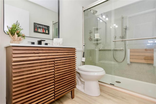 bathroom featuring vanity, radiator, hardwood / wood-style flooring, toilet, and a shower with shower door