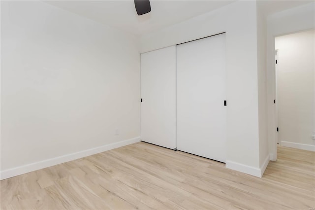 unfurnished bedroom featuring light wood-type flooring, a closet, and ceiling fan