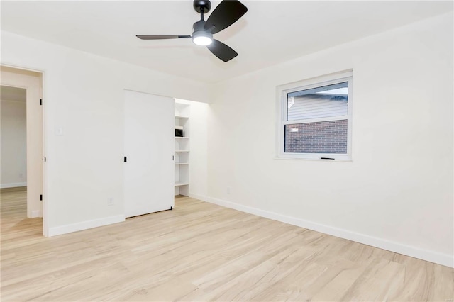 unfurnished bedroom featuring ceiling fan, a closet, and light wood-type flooring