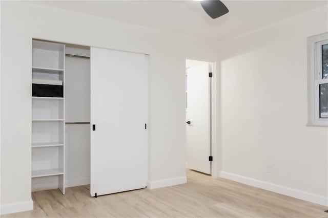 unfurnished bedroom featuring ceiling fan, a closet, and light hardwood / wood-style flooring