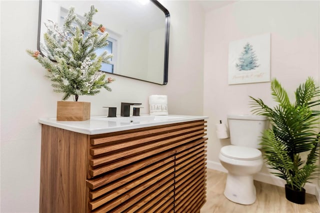 bathroom featuring hardwood / wood-style floors, vanity, and toilet