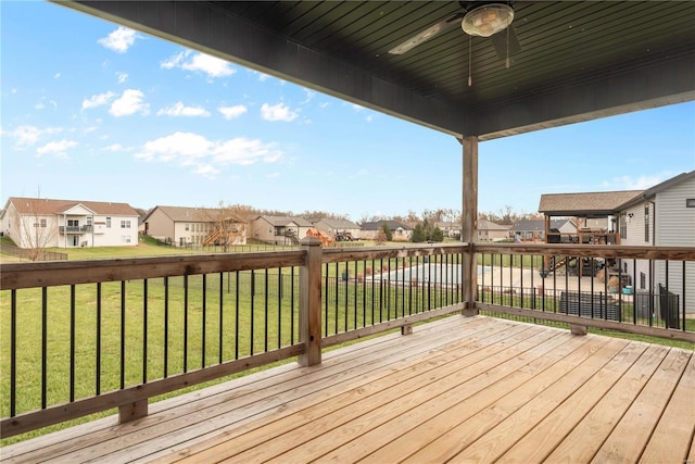 wooden deck with a lawn and ceiling fan