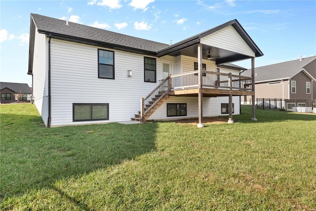 back of house featuring ceiling fan, a deck, and a yard