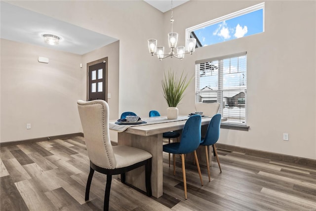 dining space featuring hardwood / wood-style flooring and an inviting chandelier