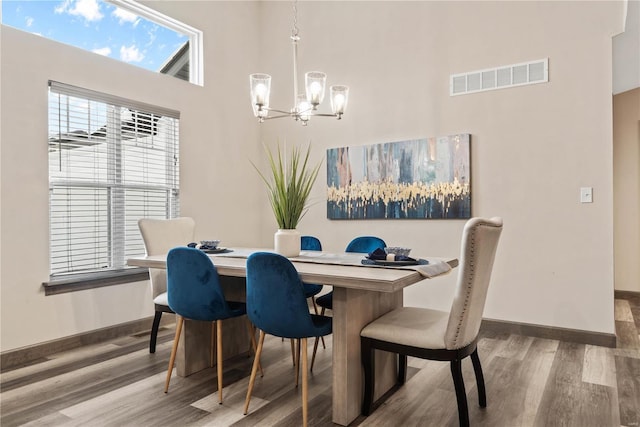 dining space featuring hardwood / wood-style flooring and a notable chandelier