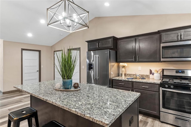 kitchen with a center island, an inviting chandelier, appliances with stainless steel finishes, decorative light fixtures, and light hardwood / wood-style floors