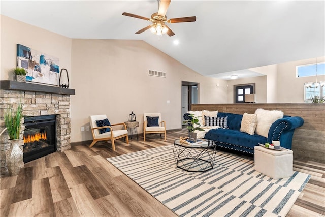 living room featuring hardwood / wood-style flooring, ceiling fan, a fireplace, and vaulted ceiling