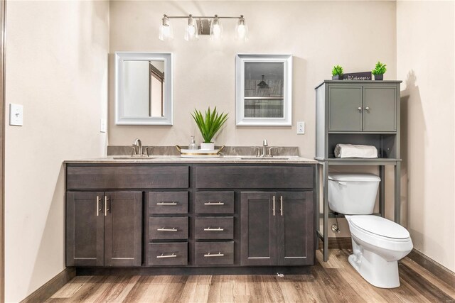 bathroom with hardwood / wood-style flooring, vanity, and toilet