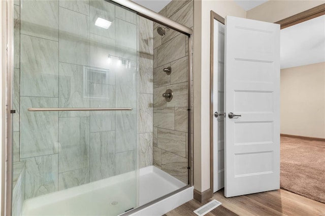 bathroom featuring hardwood / wood-style floors and an enclosed shower