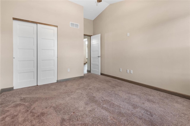 unfurnished bedroom with carpet flooring, vaulted ceiling, and a closet