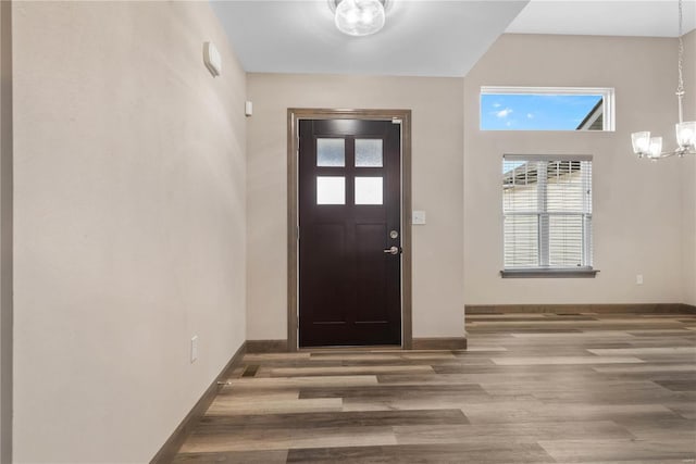 entryway featuring wood-type flooring and a chandelier